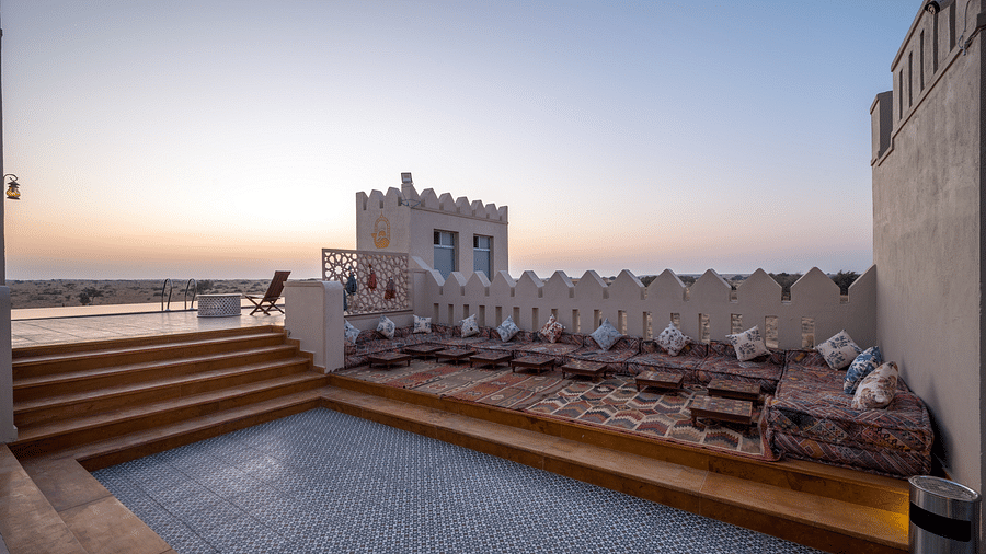 The lounge decked with cushions for sitting at the rooftop - Karwaan Jaisalmer