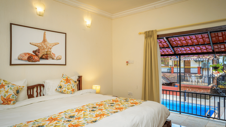 A hotel room in South Goa with a double view and a balcony that opens onto a pool - Neemranas Three Waters