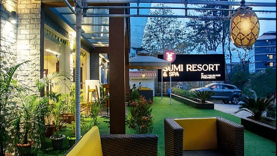 Outdoor seating with potted plants behind and a hanging light - Sumitel Gangtok