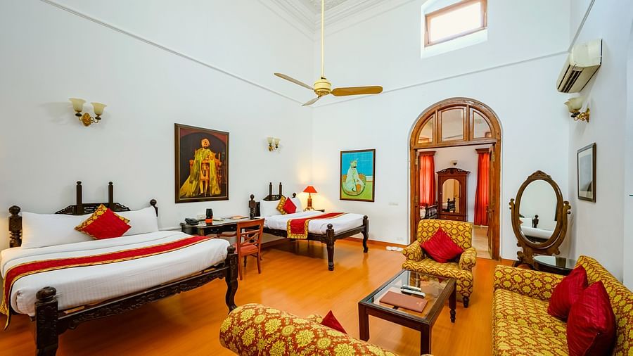 Twin double bed in front of the seating area showcasing sofas and coffee table inside Maharaja Rajinder Singh room - The Baradari Palace