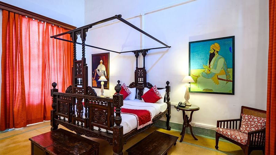 Beautifully carved double bed with a single seated next to it inside Raja Baba Ala Singh room - The Baradari Palace