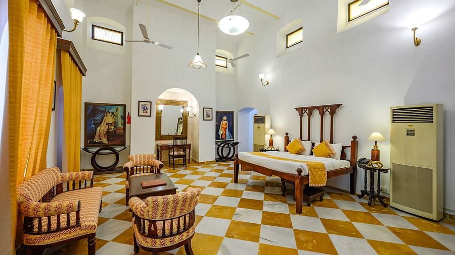A double bed, sofas with coffee table in the centre and a study table inside Maharaja Amarinder Singh room - The Baradari Palace