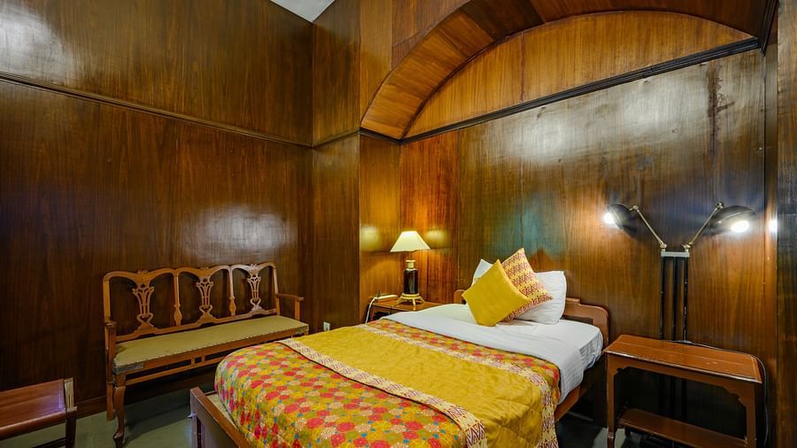 A double bed with a lamps on the side and a sofa next to it inside Maharaja Amarinder Singh room - The Baradari Palace