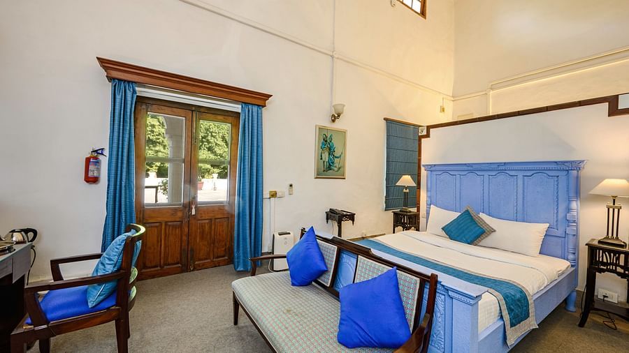 An overview of the Maharani Mohinder Kaur room with a double bed and sofa in front of the bed - The Baradari palace