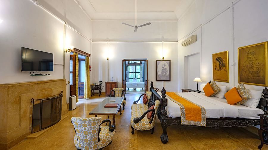 an overview of the room showcasing the bed, tv, sofas and coffee table inside Maharaja Sahib Singh room - The Baradari Palace