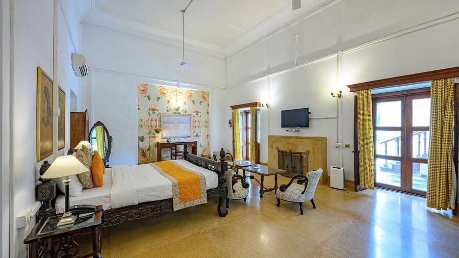 A double bed in front of sofas and TV inside Maharaja Sahib Singh room - The Baradari Palace