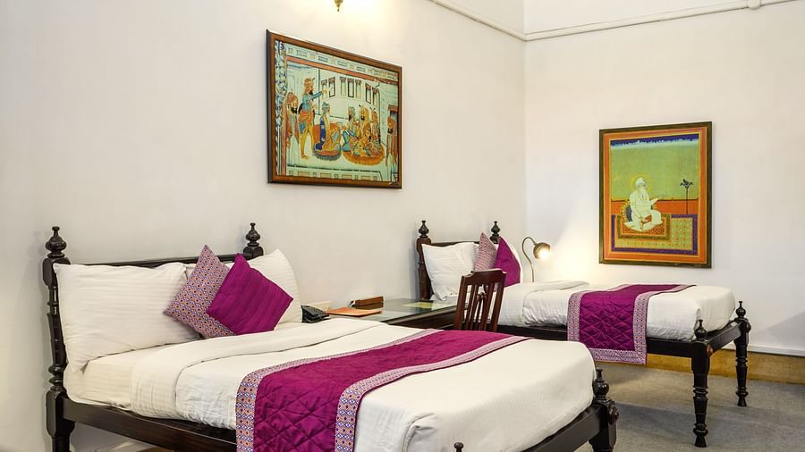 Twin double beds with a painting hanging above the head board inside Maharaja Karam Singh room - The Baradari Palace