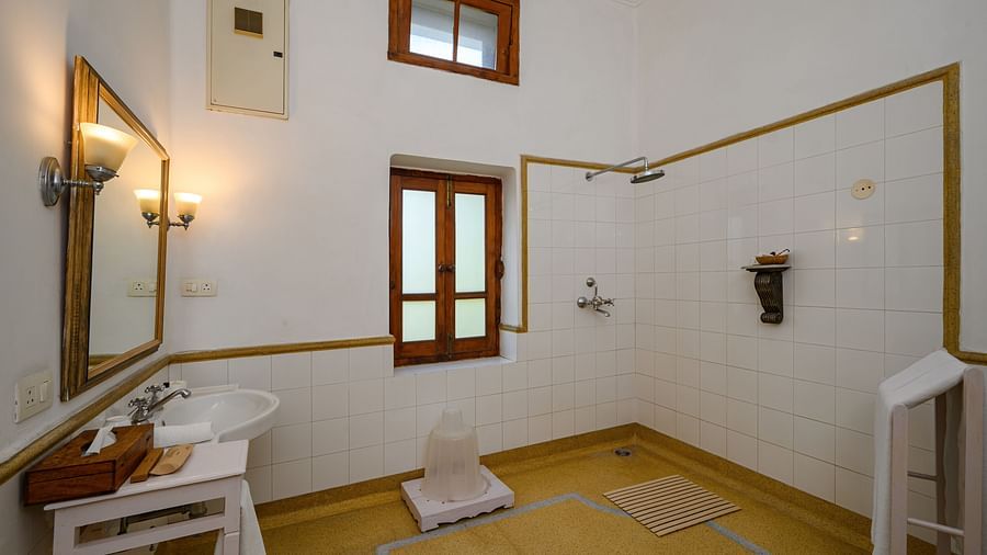 An overview of the bathroom showcasing the bath area and wash basin inside Maharajkumari Surinder Kaur room - The Baradari palace