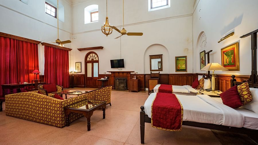 twin beds next to seating area showcasing sofas and coffee table inside Raja Amar Singh room - The Baradari Palace