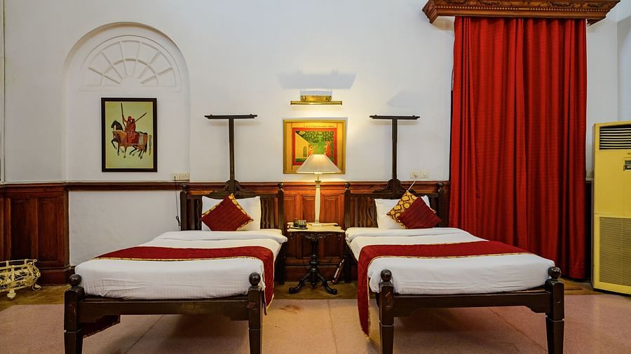 twin beds with a small table in the centre inside the Raja Amar Singh room - The Baradari Palace