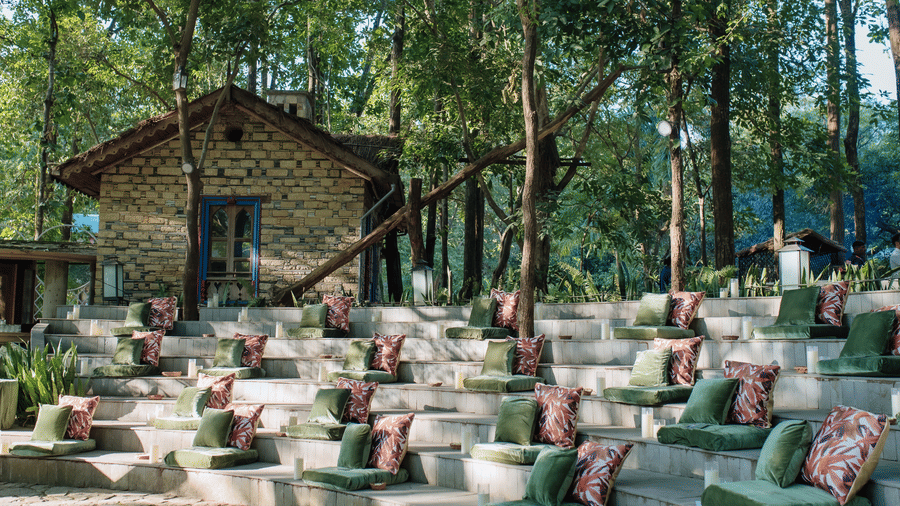 An event space at The Den Corbett Resort, with a decorated seats, flowers, and plants.