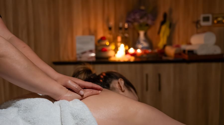 An image of a woman receiving back massage in a room - The Manor Luxury Hotel, Shimla