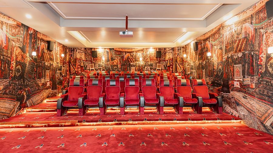 Another view of a theatre with reclining red chairs in ambient lighting - The Manor Luxury Hotel, Shimla
