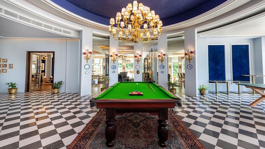 A chandelier hanging on top of a pool table placed on a carpet - The Manor Luxury Hotel, Shimla