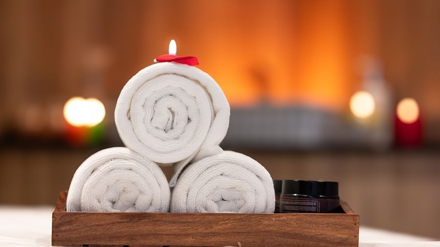 An image of three towels rolled in a wooden tray - The Manor Luxury Hotel, Shimla