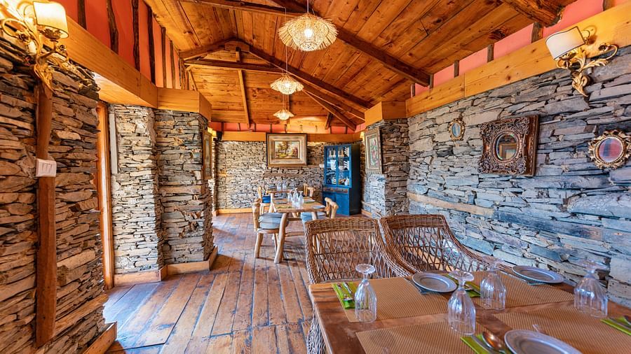 Mario Restaurant with limestone wall, wooden furniture and ambient lighting - The Manor Luxury Hotels, Shimla 