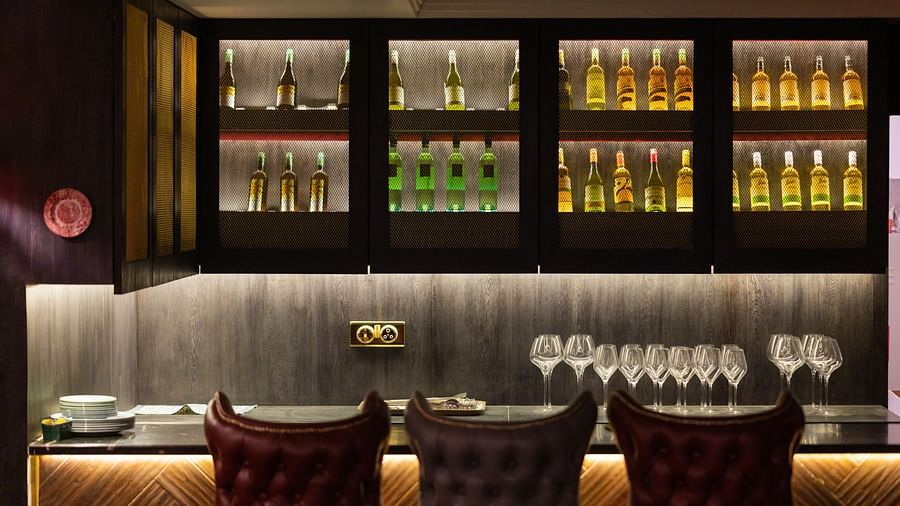 A bar counter at the restaurant with champagnes placed in cupboards - The Manor Luxury Hotel, Shimla