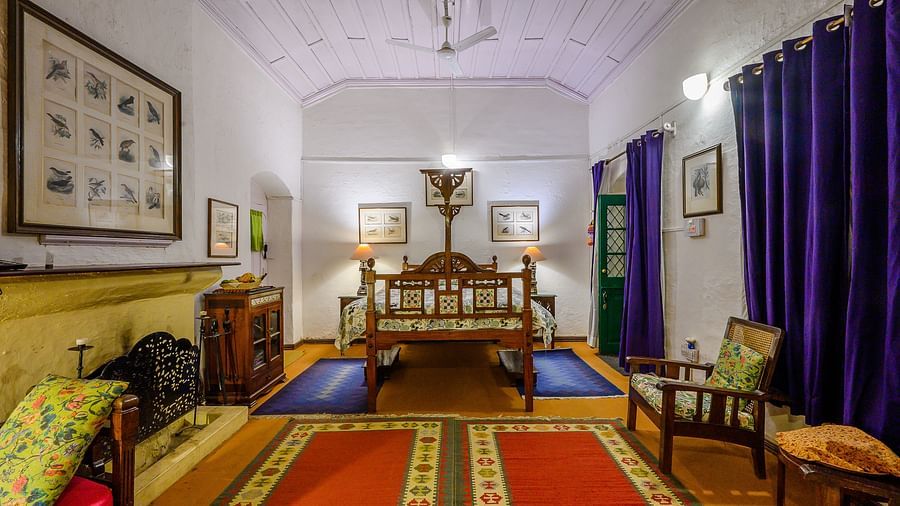 The Ramgarh Bungalows - full angle view of Bird room with one queen size bed, two couches, pristine walls, curtains and a carpeted floor