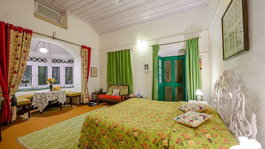 Royal butterfly room side view with king size bed and seating area in the room - Ramgarh Bungalows, Nainital.