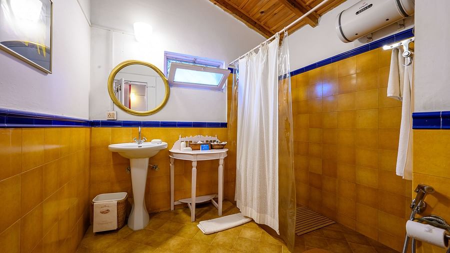 A bathroom with water heater and bathrobe - Ramgarh Bungalows, Nainital. 