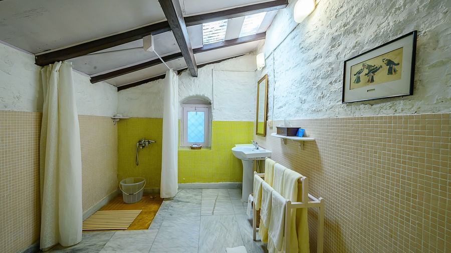A bathroom with a separate shower space inside lemon room - Ramgarh Bungalows, Nainital.