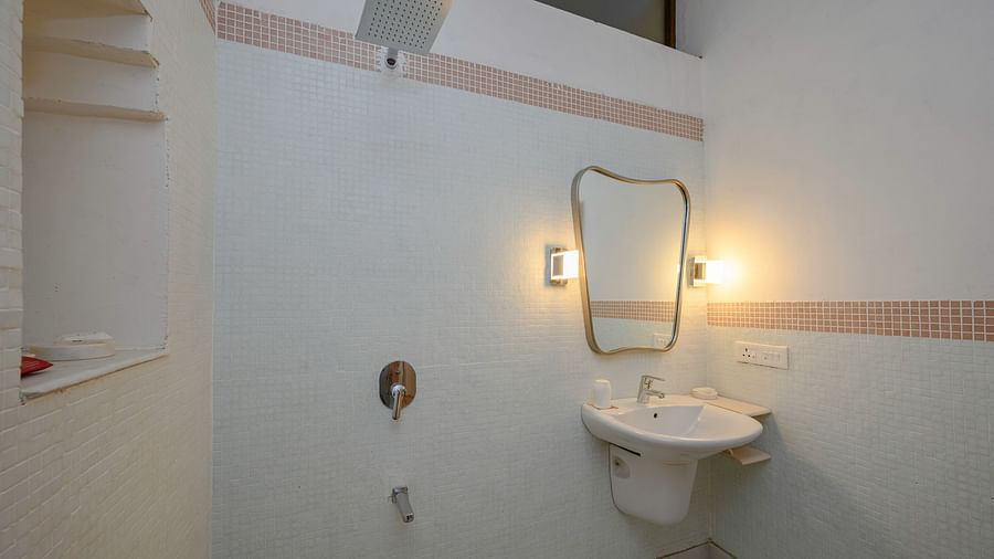 Bathroom with sink, mirror, wall lighting, shower fixtures, and tiled floor - Tijara Fort-Palace - 19th Century, Alwar.