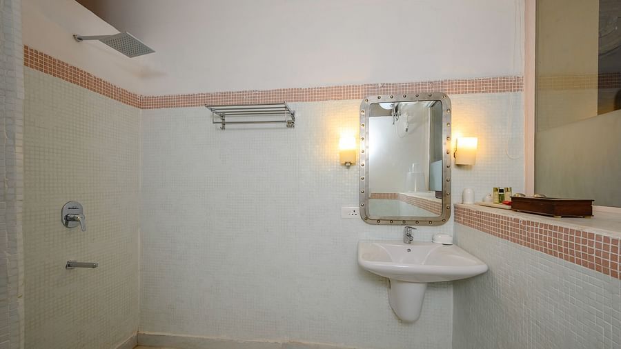 Bathroom with sink, mirror, wall lighting, shower area, and towel rack - Tijara Fort-Palace - 19th Century, Alwar.