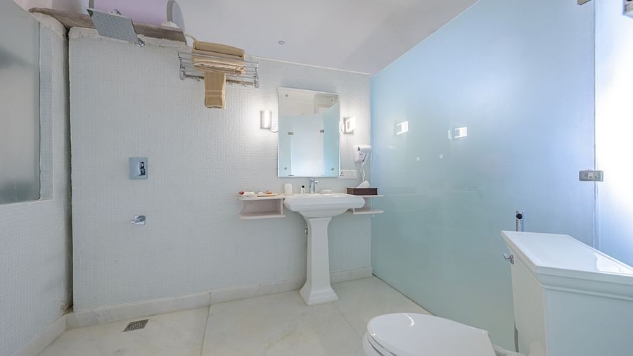 Bathroom with toilet, sink, mirror, shower, and towel rack - Tijara Fort-Palace - 19th Century, Alwar.