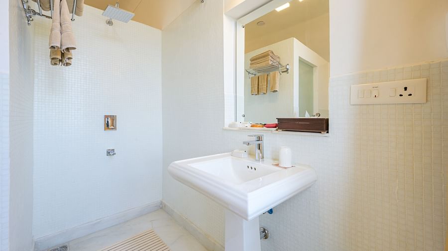 Bathroom with sink, mirror, shower, towel rack, and outlet - Tijara Fort-Palace - 19th Century, Alwar.