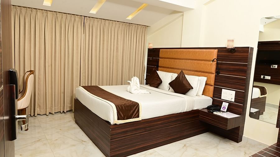 a double bed with side tables and a study table in front of it inside one of the room at VITS shanti solitaire, North Goa