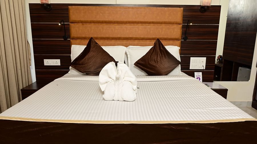 a closer view of the double bed with pillows on it and side tabled next to it inside one of the rooms at VITS shanti solitaire, North Goa