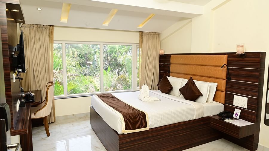 a double bed with a study table in front of it inside one of the rooms - VITS shanti solitaire, North Goa