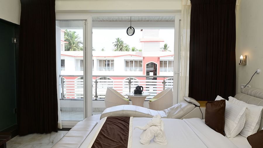 side view of the modern bed with floor to ceiling glass sliding door to the balcony inside one of the rooms at VITS shanti solitaire, North Goa