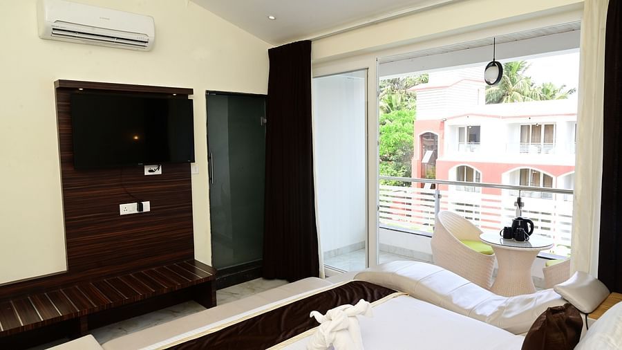 a wardrobe, tv, ac in front of the modern bed inside one of the rooms at VITS shanti solitaire, North Goa
