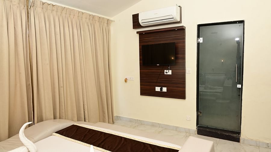 Tv and AC wall mounted opposite a double bed inside one of the rooms at VITS shanti solitaire, North Goa