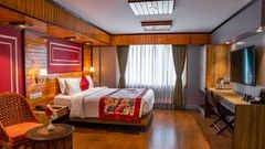 Spacious and elegant room with wooden décor, cozy bedding, and modern amenities at Mount Conifer Suites & Spa, Darjeeling.