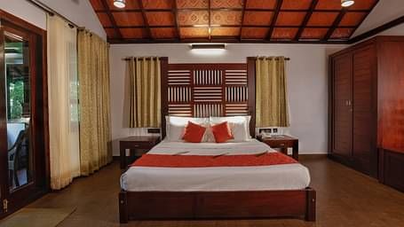 A front view of a bed placed in a room | Vythiri Resort, Wayanad