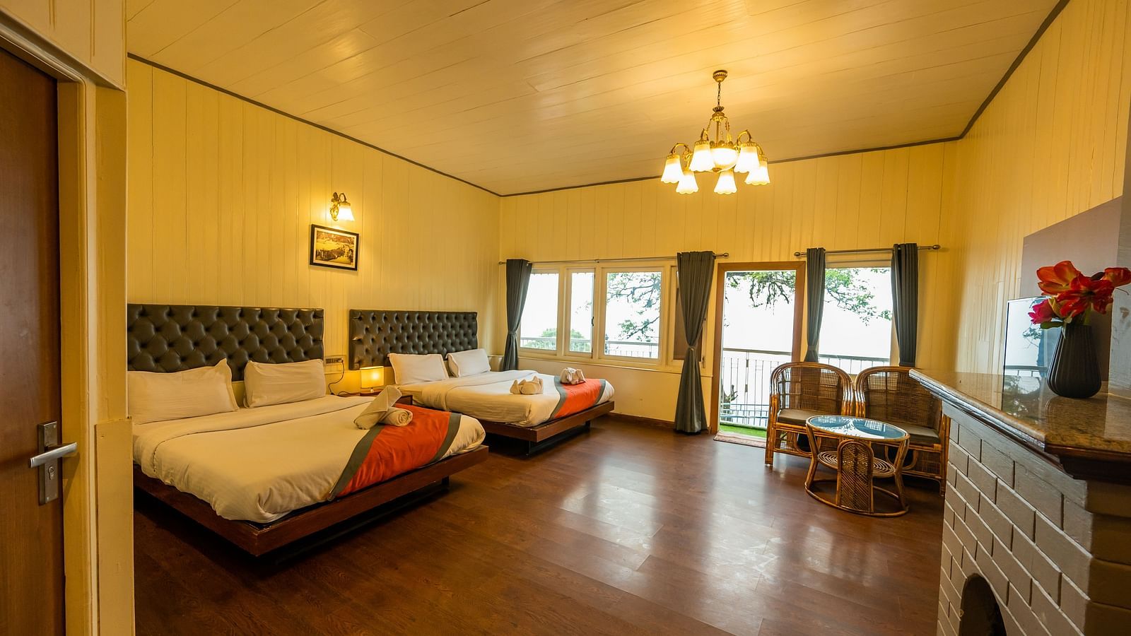 A spacious family room with 2 comfy beds, table, open window with a beautiful view  at Arcadia Heritage Resort, Darjeeling