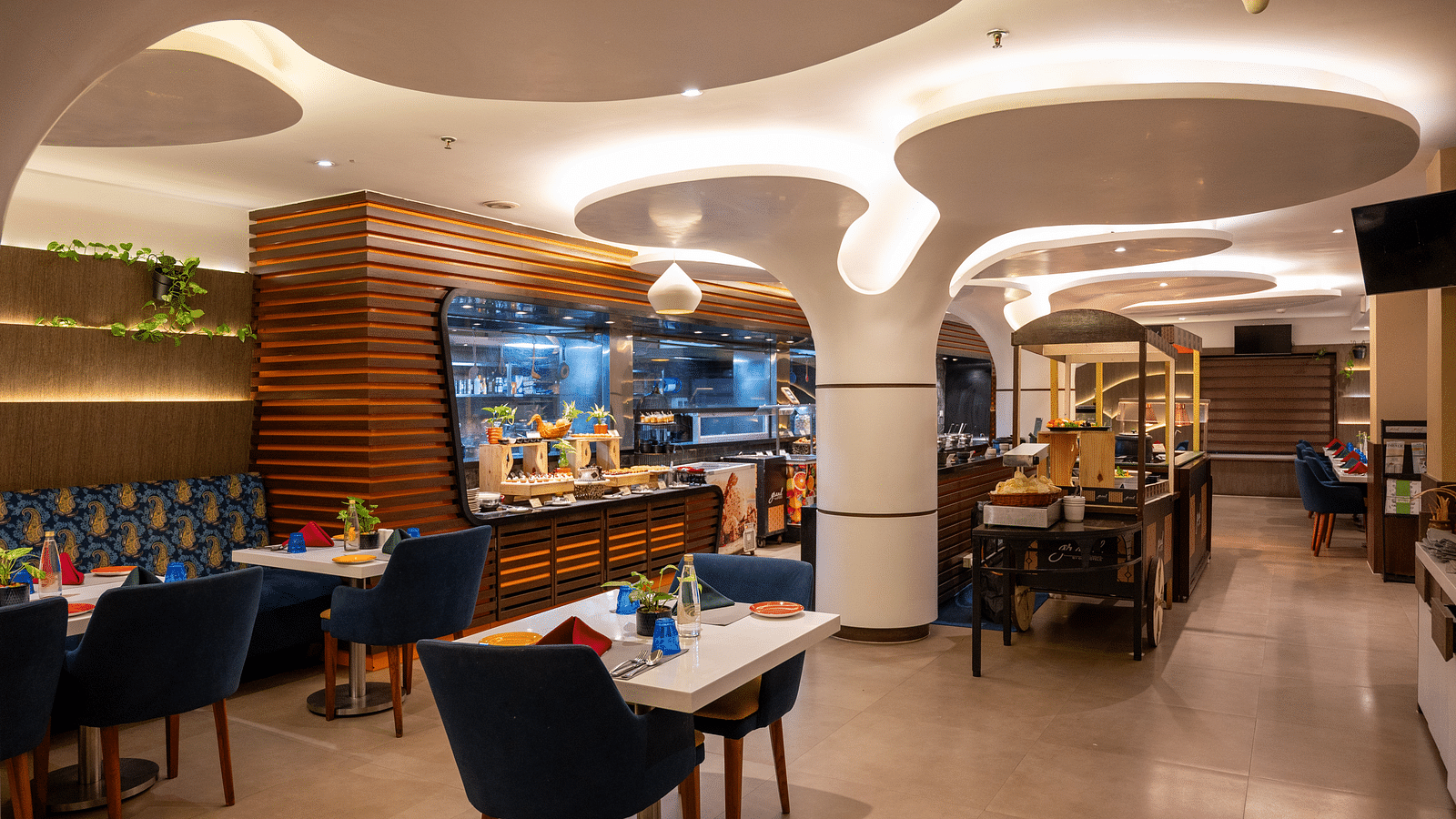 An image of a dining space with a designed ceiling at Grand Kakinada by GRT Hotels