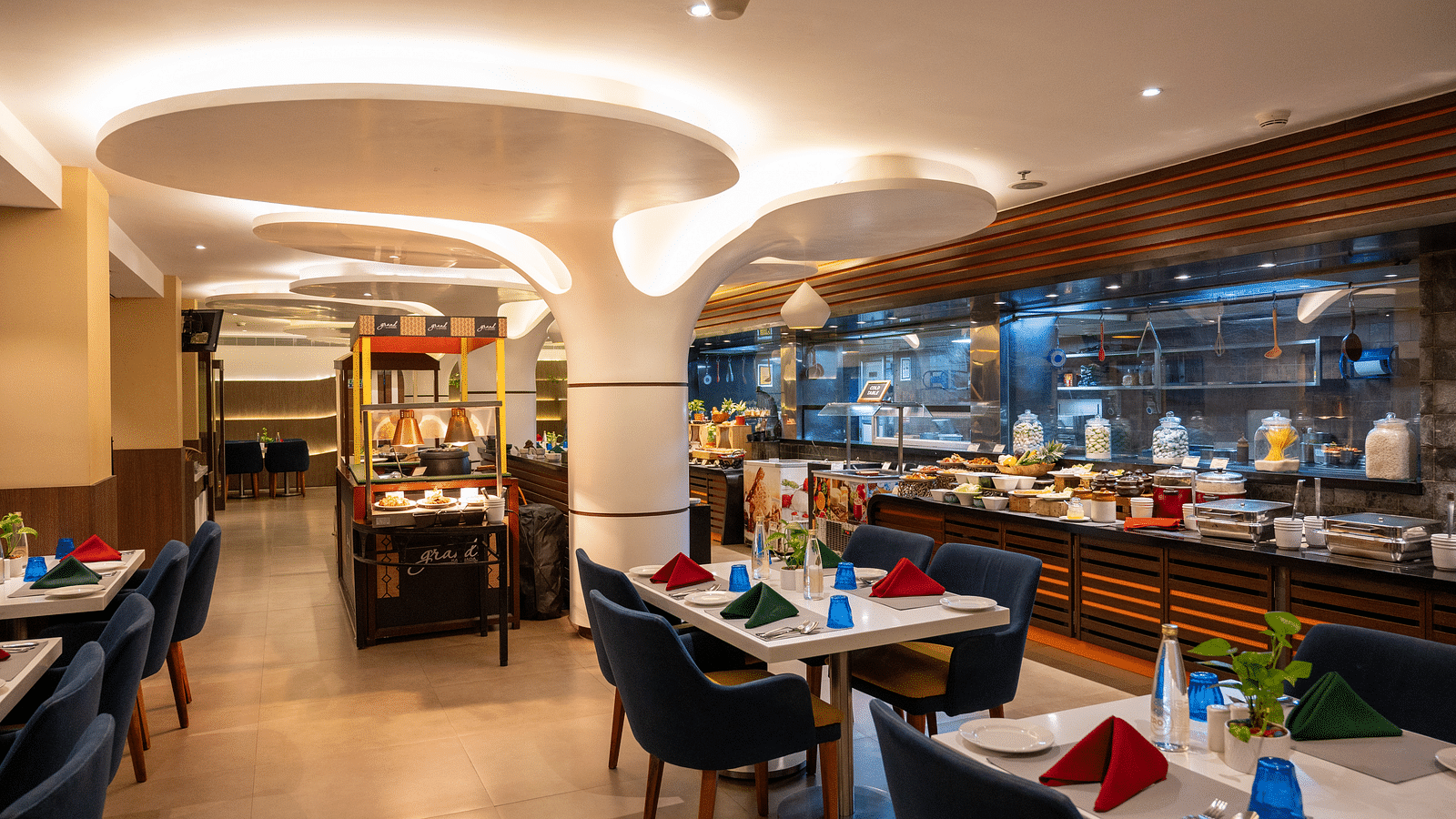 An image of dining space with tables and chairs at Grand Kakinada by GRT Hotels