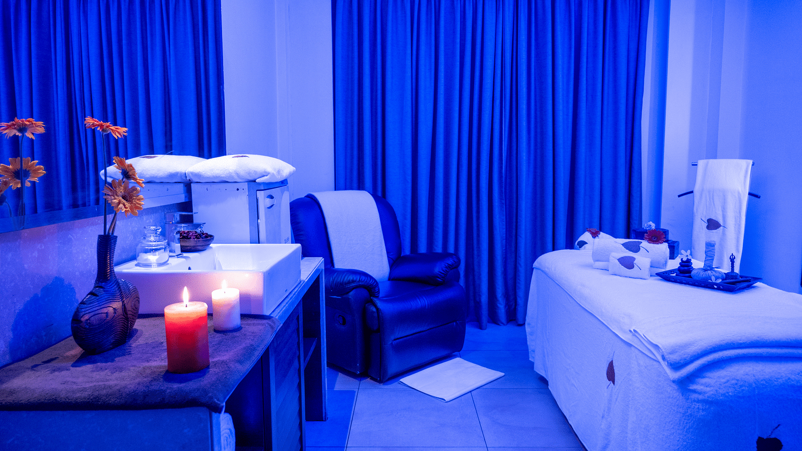 An image of a spa room with candles and massage chair at image of an event hall with tables and chairs at Grand Kakinada by GRT Hotels