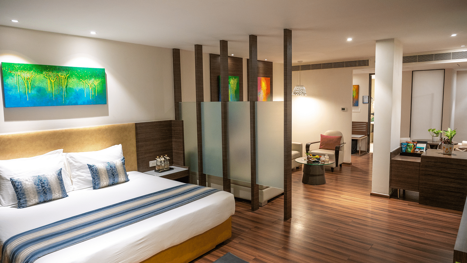 An image of a bedroom with a living space at  Grand Kakinada by GRT Hotels