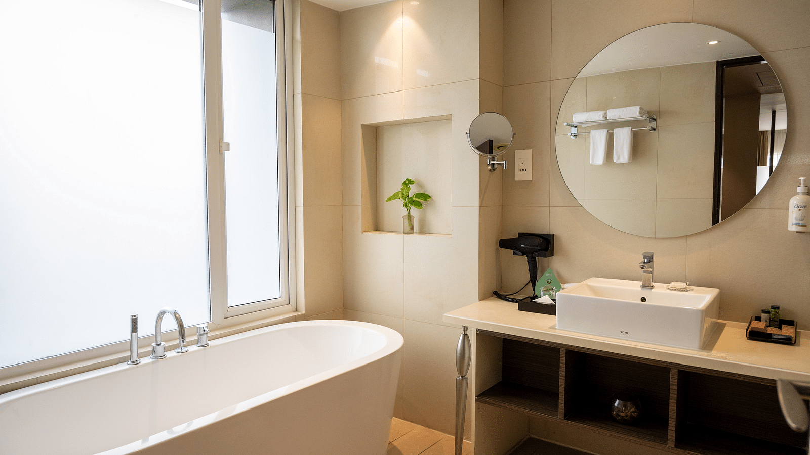 An image of a bathroom with a bath tub and a mirror at Grand Kakinada by GRT Hotels