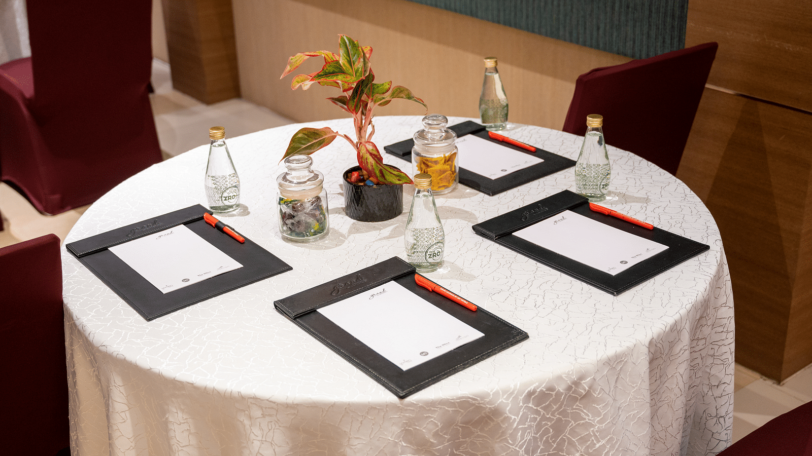 An image of note pads and glass bottles arranged on the table at Grand Kakinada by GRT Hotels