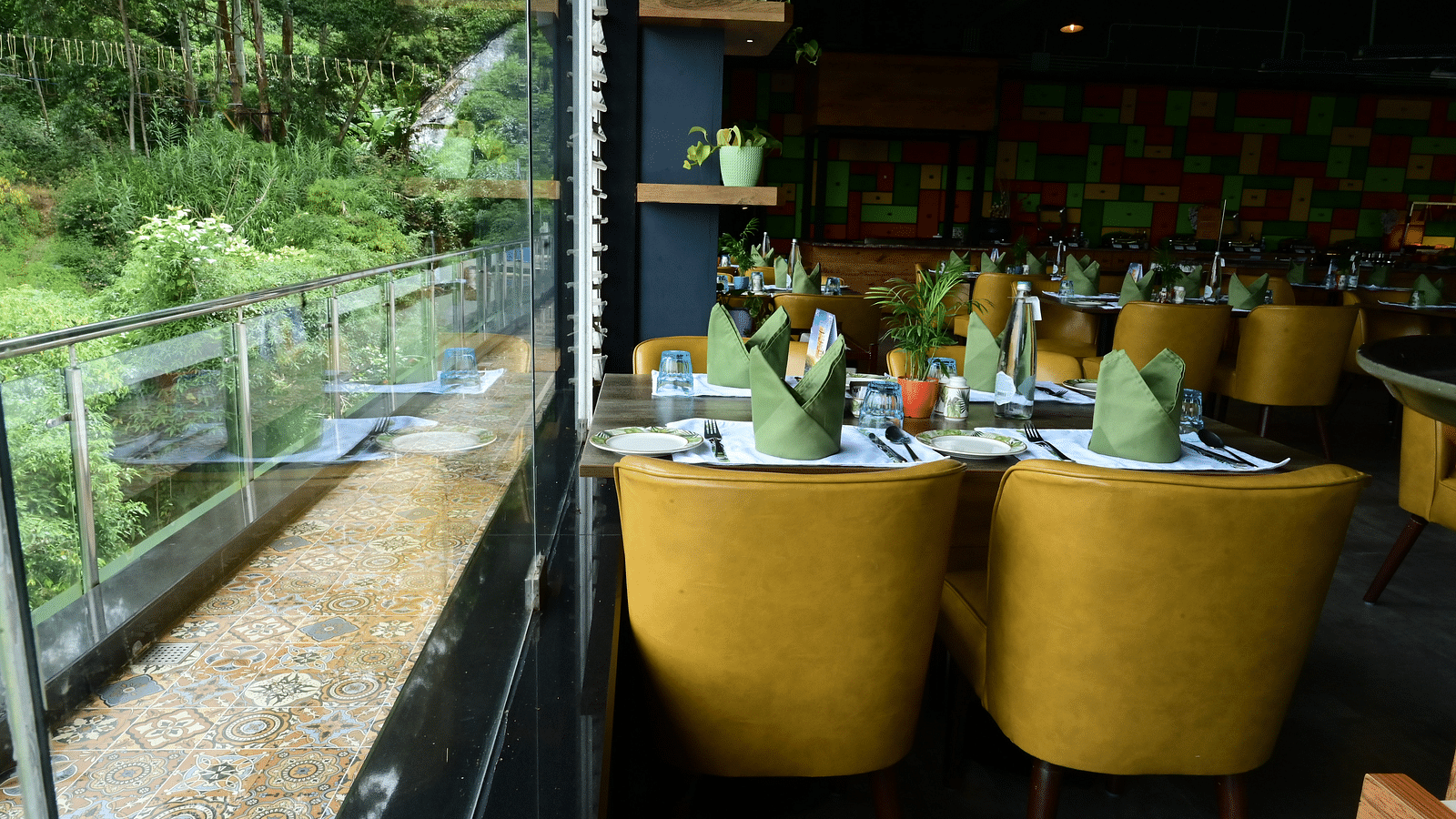 An image of a restaurant with seating arrangement, cutlery, and decorative items - GReaT trails Kodaikanal by GRT Hotels