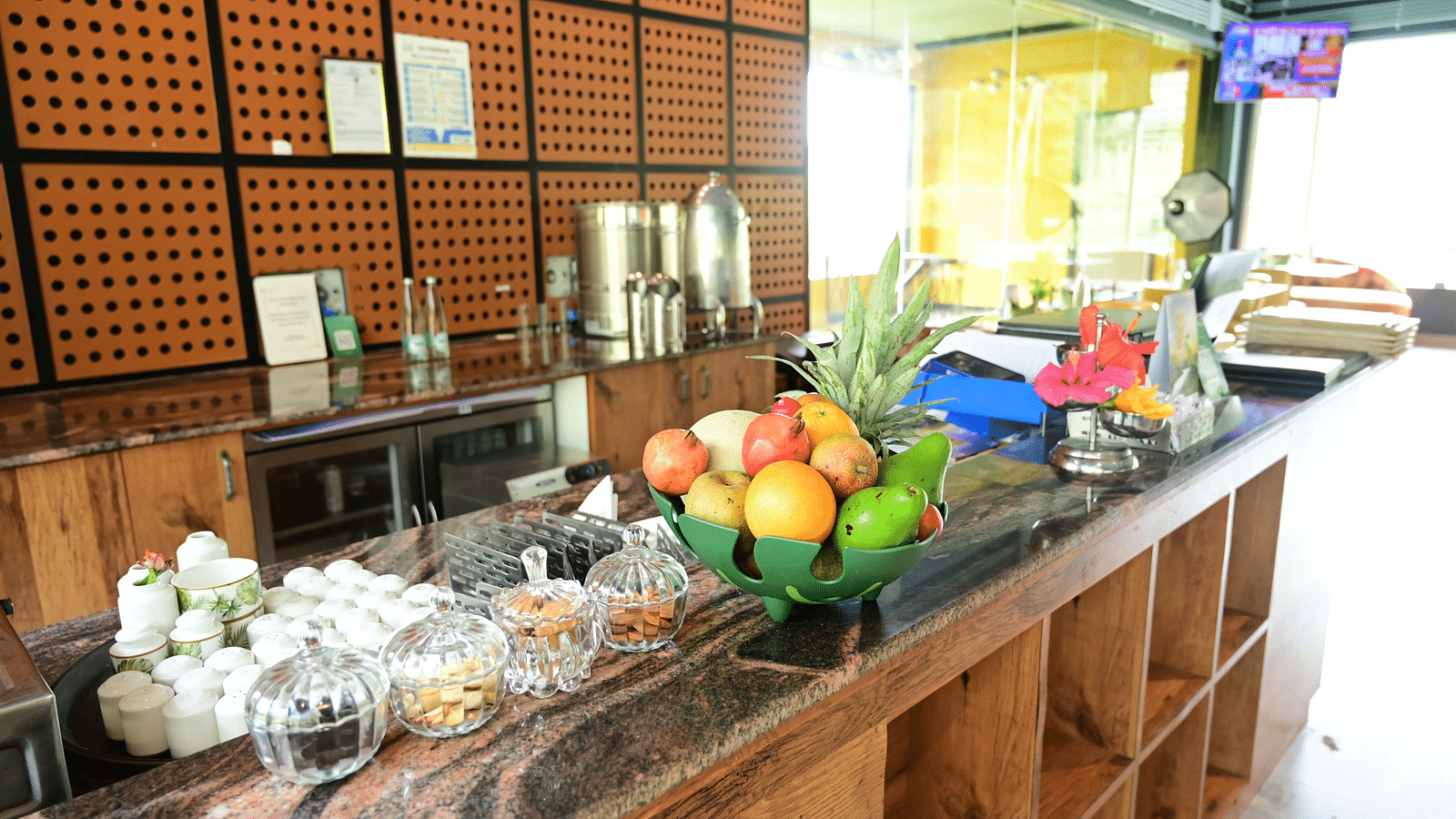 An image of a counter at the restaurant with fruits, crockery, and utensils - GReaT trails Kodaikanal by GRT Hotels