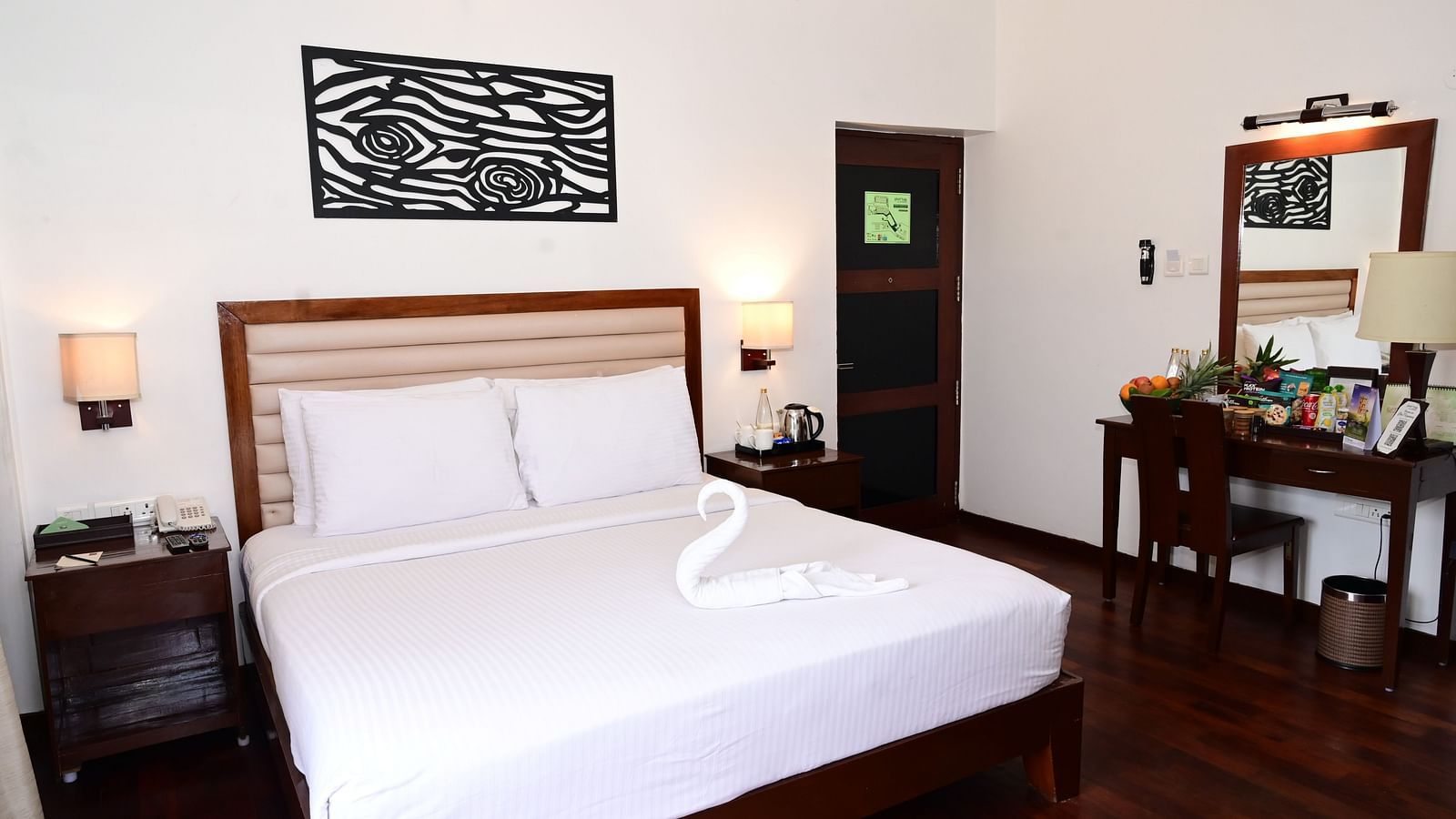 An image of a Rock Cabin Valley View with a king size bed, bed side table, lamps, ceiling fan, dressing table, and a chair - GReaT trails Kodaikanal by GRT Hotels