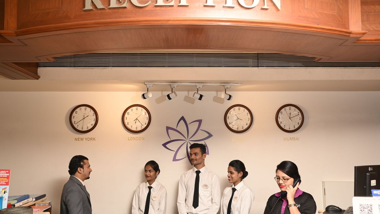A guest interacting with the reception staff at a hotel - Kamats India