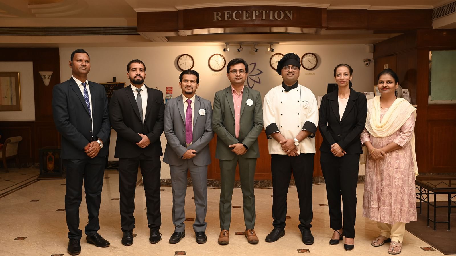 Staff members posing together in front of the reception area at VITS Sharanam - Kamats India