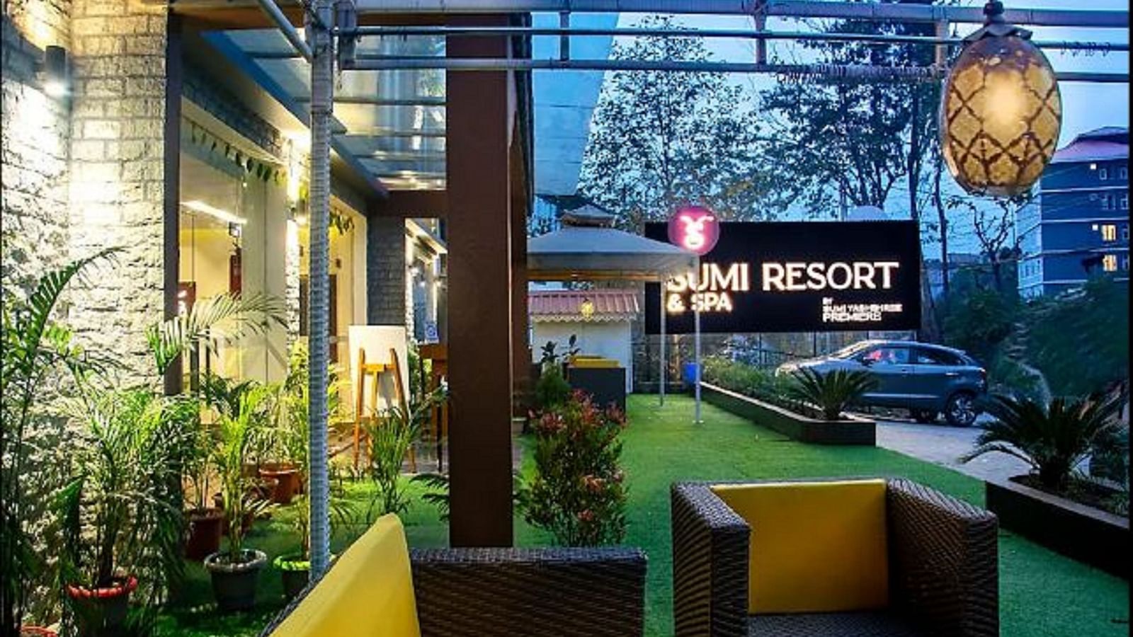 Outdoor seating with potted plants behind and a hanging light - Sumitel Gangtok